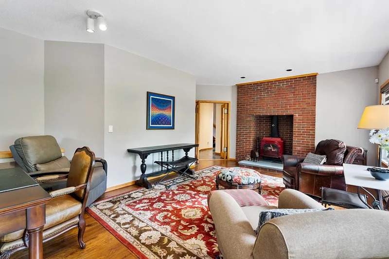Wood burning stove and abundant natural light enhance the family room