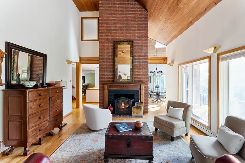 Warm yourself by the fireplace in this stunning, light-filled great room featuring soaring ceilings.